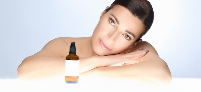 Serene natural beauty woman with skincare product on a bright background, showcasing elegance and health in skincare advertisement.