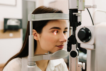 Girl is visiting ophthalmologist for eye examination. Ophthalmology procedure with slit lamp for...