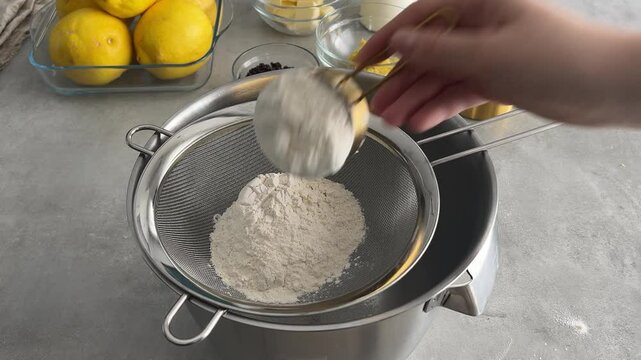 Measuring and sifting flour through a sieve for baking preparation