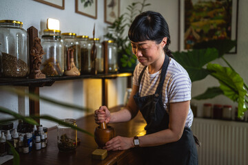 japanese woman use mortar and pestle on a wooden table to make soap