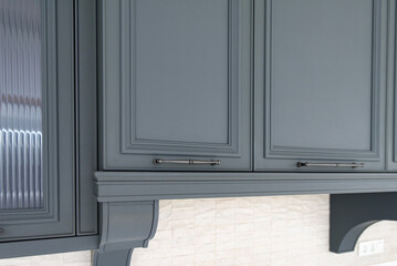 Upper cabinets with metal handles on a classic kitchen wall