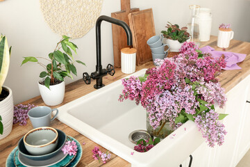 Blooming lilac twigs in kitchen sink