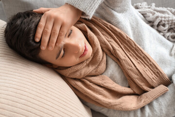 Sick little boy lying on sofa at home, closeup
