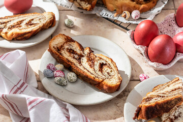 Easter baking. Homemade Easter Chocolate babka or brioche bread cutted with easter eggs and flowers in bright sunlight. Sweet yeast dough with chocolate filling
