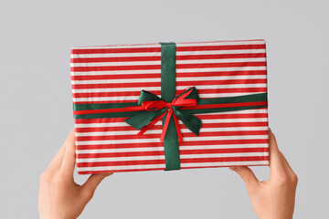 Female hands holding Christmas gift box on white background