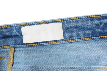 Clothing label inside jeans on white background. Close up. Denim jeans and fabric tag label mockup suitable for showcasing brand identity and product details.