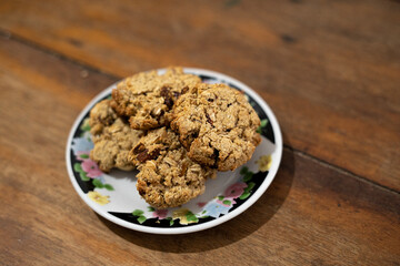 cookies, oatmeal cookies resting over a little dish plate, on a wooden table