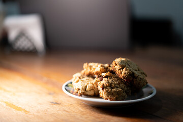 cookies, oatmeal cookies resting over a little dish plate, on a wooden table