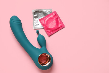 Sex toy with condoms on pink background