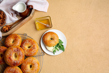 Stand and plate with tasty bagels on beige background