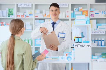 Male pharmacist with prescription medicine for customer at pharmacy