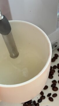 Disabled man with silicone prosthesis hand, barista without arm working in cafe steaming milk in coffee machine pitcher. Physical disability people at work, inclusion and inclusiveness concept