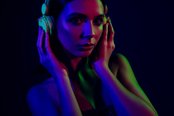 Young woman with headphones in neon lighting, expressing fashion, passion, glamour, and party vibes...