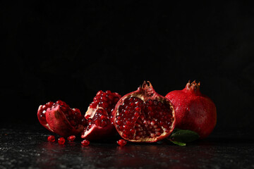 Pieces of ripe tasty pomegranate on black background