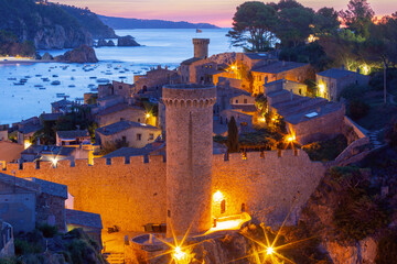 Medieval stone towers and coastal village at sunrise in Tossa de Mar, Spain