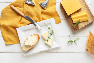Composition with tasty processed cheese, bread and micro green on light wooden background