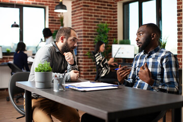 Caucasian applicant listens closely to african american recruiter discussing the hiring process. HR...