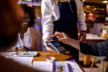 Young man paying with his credit card in a sushi restaurant