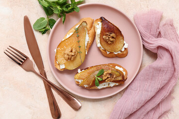 Plate of pear bruschetta with ricotta cheese and walnuts on beige background
