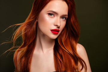 Fototapeta premium Portrait of stunning adorable lady shiny ginger hair enjoying red pomade isolated khaki color background