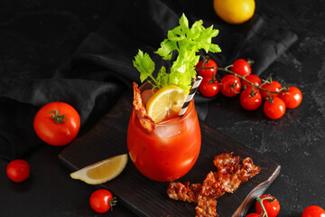 Glass of bloody mary cocktail with bacon, celery and lemon on black background, closeup