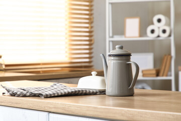 Teapot with ceramic butter dish on table in kitchen