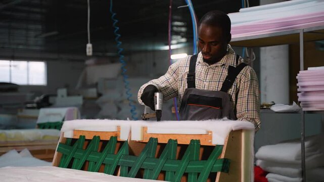 Man Using Staple Gun on Sofa Frame Upholstery