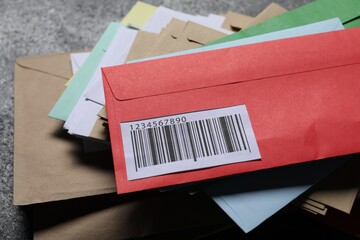 Stack of different paper envelopes on dark grey table, closeup. Post office