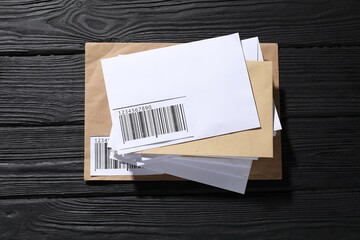 Different paper envelopes on black wooden table, top view. Post office