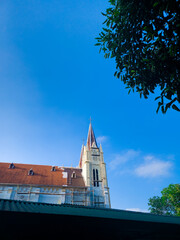 A tall church tower with a blue sky background