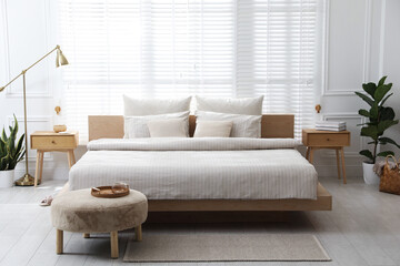 Fototapeta premium Comfortable bed with soft linens in stylish room. Interior design