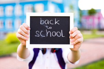 Child holding blackboard with chalk text Back to School
