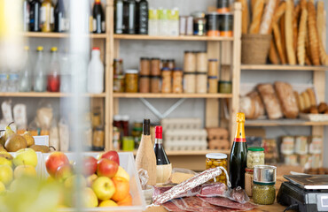 Various products on the store counter - cheese, canned olives, fruits, dried sausages and many other delicious products