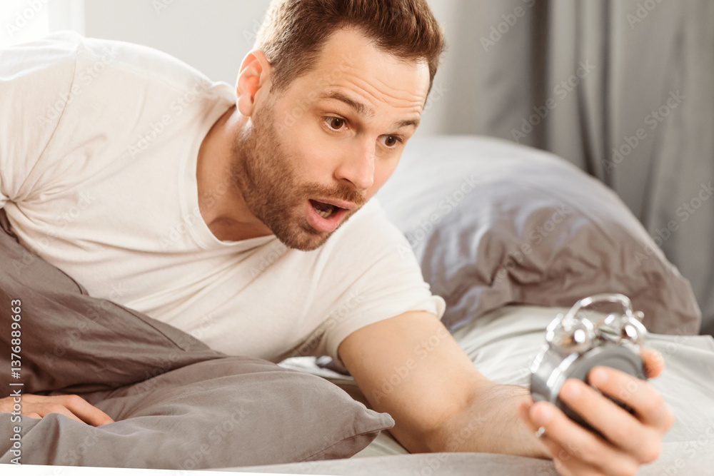 Poster oversleeping problem. shocked overslept guy holding alarm clock lying in bed, waking up too late for
