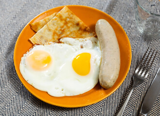 Delicious pancakes with scrambled eggs and sausage. Healthy breakfast