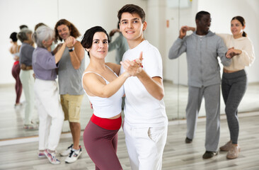 Fototapeta premium Caucasian man and lady rehearsing latin paired dance moves