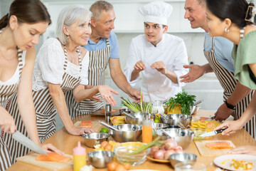 Professional personal chef cook in customer private kitchen house giving a cooking lesson to people at home