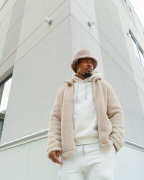 Young Man Standing on Downtown Corner Looking Across The Street 