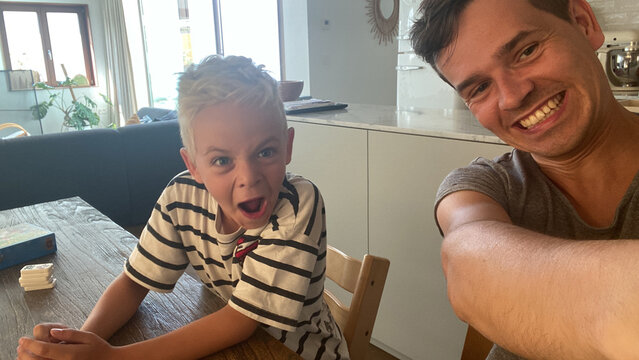 UGC joyful moment: boy and adult making funny faces together at home