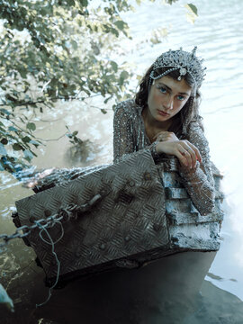 Woman in Tiara and Glittering Dress Leaning on a Boat