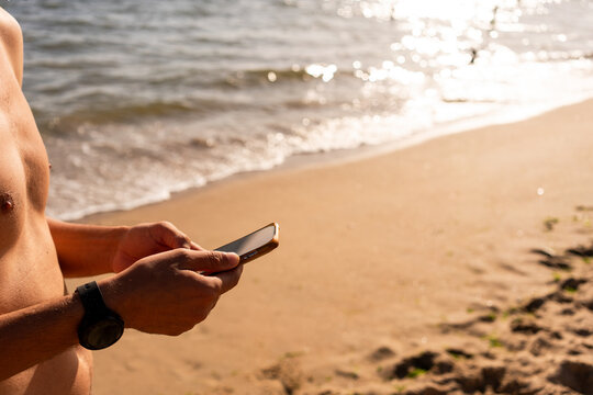 Man Using Smartphone on Beach