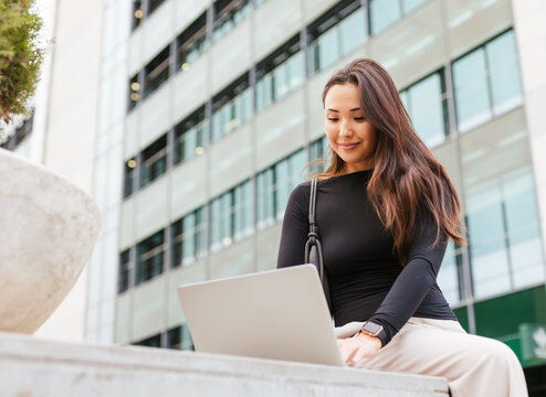 an asian girl using her laptop