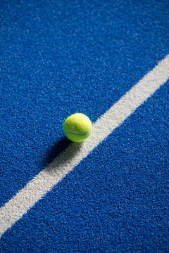 Tennis Ball on White Line of a Blue Padel Court