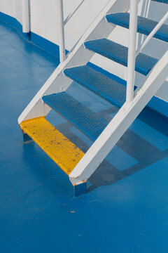 Metal staircase with blue and yellow steps on a ferry deck