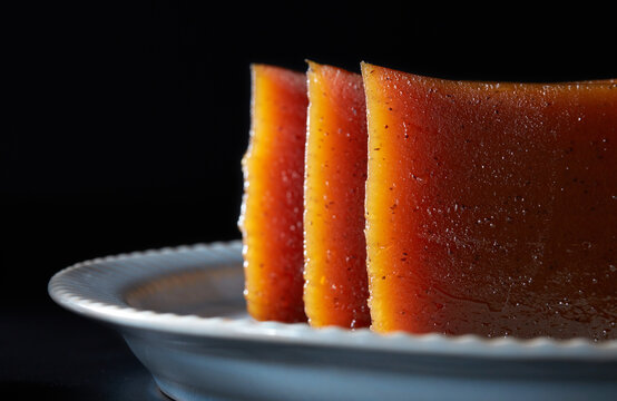 Closeup of red date cake on a plate with black background