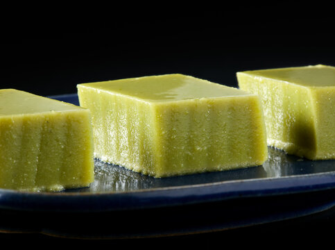 Closeup of mung bean cake on a plate with black background
