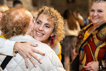 Woman affectionately embracing senior woman at a social gathering