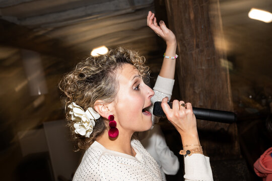 Singer performing with microphone, raising hand and singing