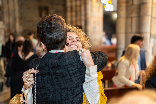 Two women hugging inside a church after a ceremony