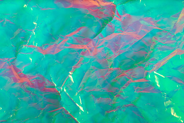 Holographic surface with mix of shiny pink and green hues